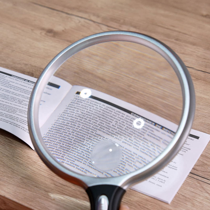 Loupe éclairante Supra agrandissant un texte imprimé pour une lecture claire.
