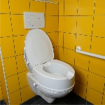Réhausse WC Ibiza avec couvercle installée sur des toilettes à côté d'une barre d'appui - réf. 81109