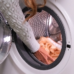 Personne qui met le coussin chauffant électrique dans la machine à laver