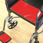 Antidérapant Dycem rouge appliqué sur l'assise et le repose-pied d'un fauteuil roulant