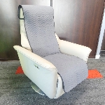Protection imperméable grise installée sur un fauteuil releveur, en situation