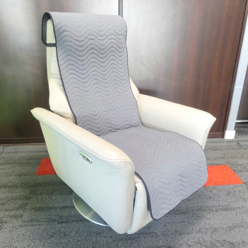 Protection imperméable grise installée sur un fauteuil releveur, en situation