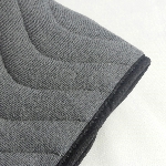 Gros plan sur la texture matelassée et le biais noir de la protection pour fauteuil