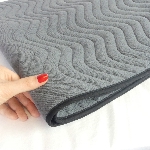 Zoom sur le matelassage et la finition en biais noir de la protection imperméable pour fauteuil