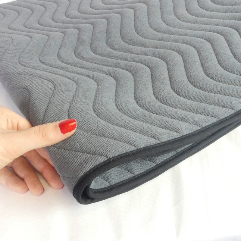 Zoom sur le matelassage et la finition en biais noir de la protection imperméable pour fauteuil