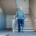 Béquille mains libres I-Walk utilisée par une personne âgée pour descendre des escaliers - réf. 8160