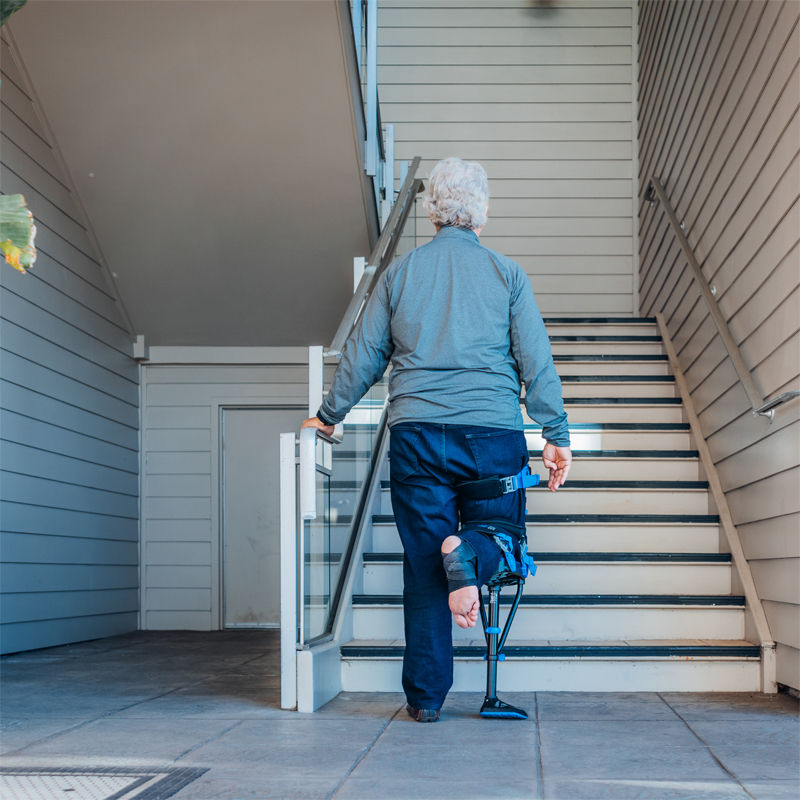 Béquille mains libres I-Walk utilisée par une personne âgée pour descendre des escaliers - réf. 8160