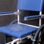 Assise étanche de la chaise de douche et WC Aston grandes roues sous la douche, couvercle fermé - ré