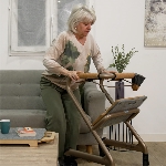 Femme en appui sur les poignées du rollator d'intérieur Saljol dans un salon - réf. 826307BL