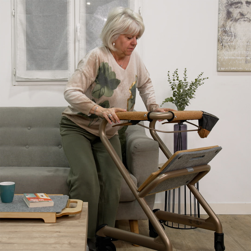 Femme en appui sur les poignées du rollator d'intérieur Saljol dans un salon - réf. 826307BL