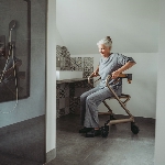 Femme assise sur le rollator d'intérieur Saljol dans une salle de bain - réf. 826307BL