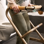 Femme debout devant des toilettes avec le rollator d'intérieur Saljol comme support de relevage - ré