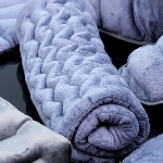 Coussin universel à chauffer en graines de lin roulé, pratique et souple pour le rangement.