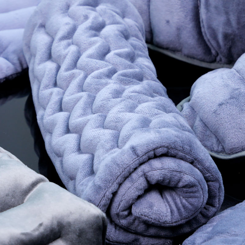 Coussin universel à chauffer en graines de lin roulé, pratique et souple pour le rangement.
