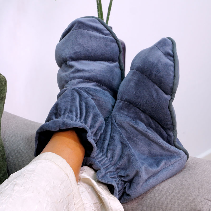 Paire de chaussons à chauffer en graines de lin gris anthracite portés aux pieds.