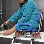 Utilisatrice assise dans le fauteuil d'accès au bain Soft se lavant la jambe à la douchette