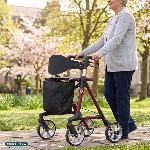 Senior marchant avec le rollator Magnus prune dans un parc fleuri - réf. 826322PRUNE