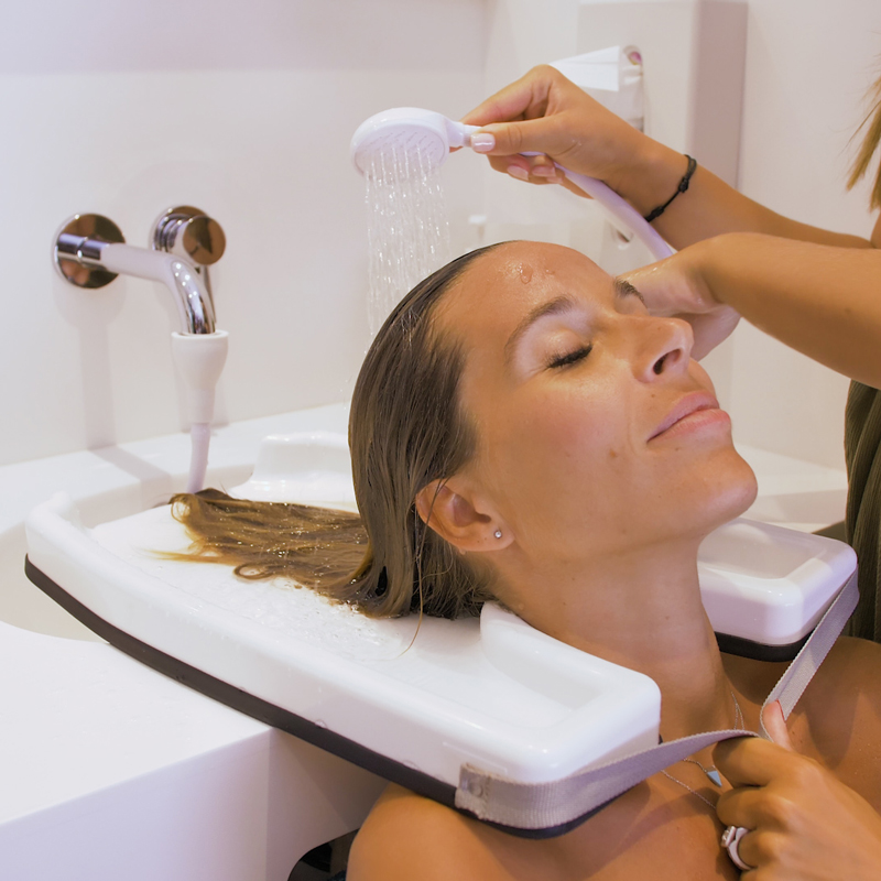 Personne qui utilise le plateau lave-tête pour fauteuil